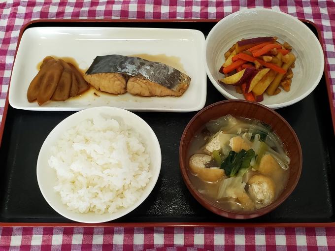 配膳されたさわらのお酢煮、さつまいもとにんじんのクルミ炒め、野菜たっぷり味噌汁、白ごはんの写真
