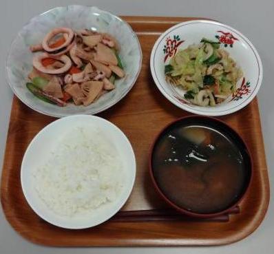 配膳されたいかと春野菜の炒め物、キャベツとわけぎのごま和え、じゃがいもと厚揚げの味噌汁、白ごはんの写真