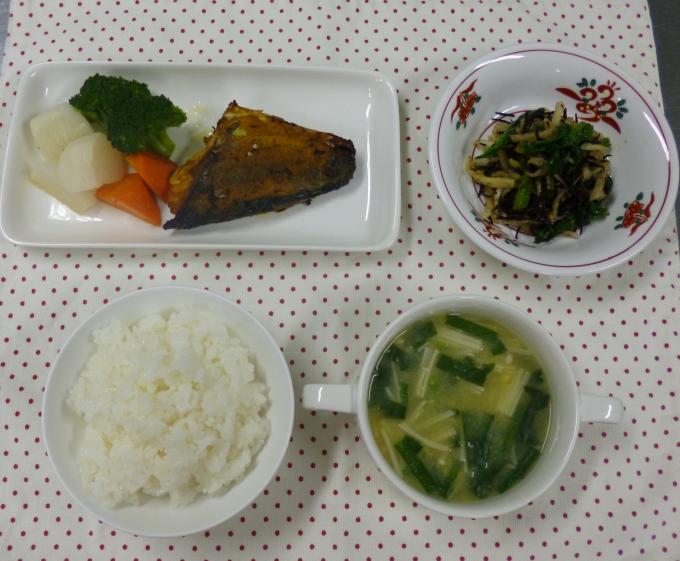 配膳されたタンドリーさば、ひじきと切り干し大根のごまポン酢和え、ニラの中華風コーンスープ、白ごはんの写真