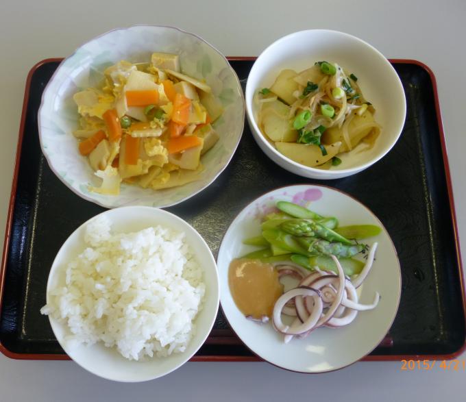 配膳された高野豆腐と春野菜の卵とじ、新じゃがのバター醤油炒め、アスパラガスといかの酢味噌がけ、白ごはんの写真