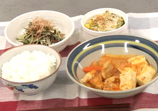 配膳されたトマトチゲ、あらめと水菜の煮びたし、ブロッコリーのアボカドチーズ焼き、白ごはんの写真
