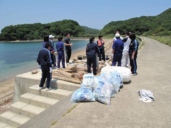 海岸近くの階段に集まる学生たち