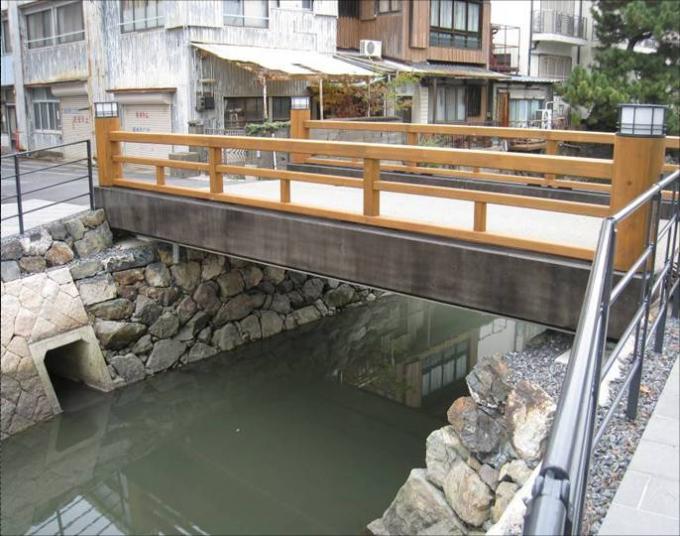 木製の欄干の上にライトがついた、相橋の写真