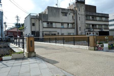 灰色の建物の側にあるベージュの石が敷き詰められた大黒橋の写真
