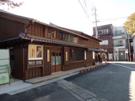住宅街にある、玄関まわりに看板が飾られた、木造2階建てのかどやの写真