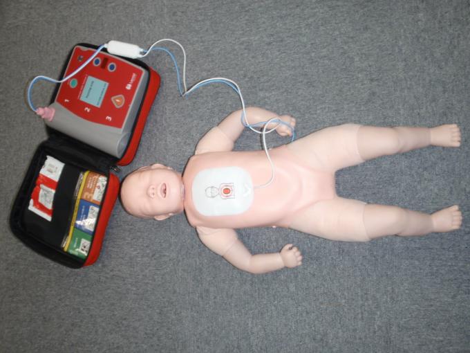 仰向けに寝ている小児用の人形の胸部に、AEDの電極パッドを貼り付けた写真