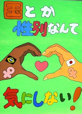 緑色の背景に、肌の色の違う手二人がハートを囲む様に描かれています。標語は「国とか性別なんてきにしない！」です。