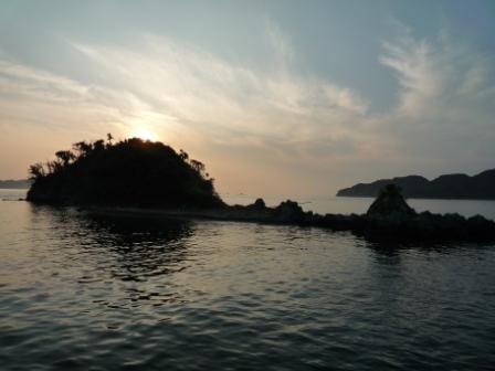 海の向こうに見える島が夕日に照らされている写真