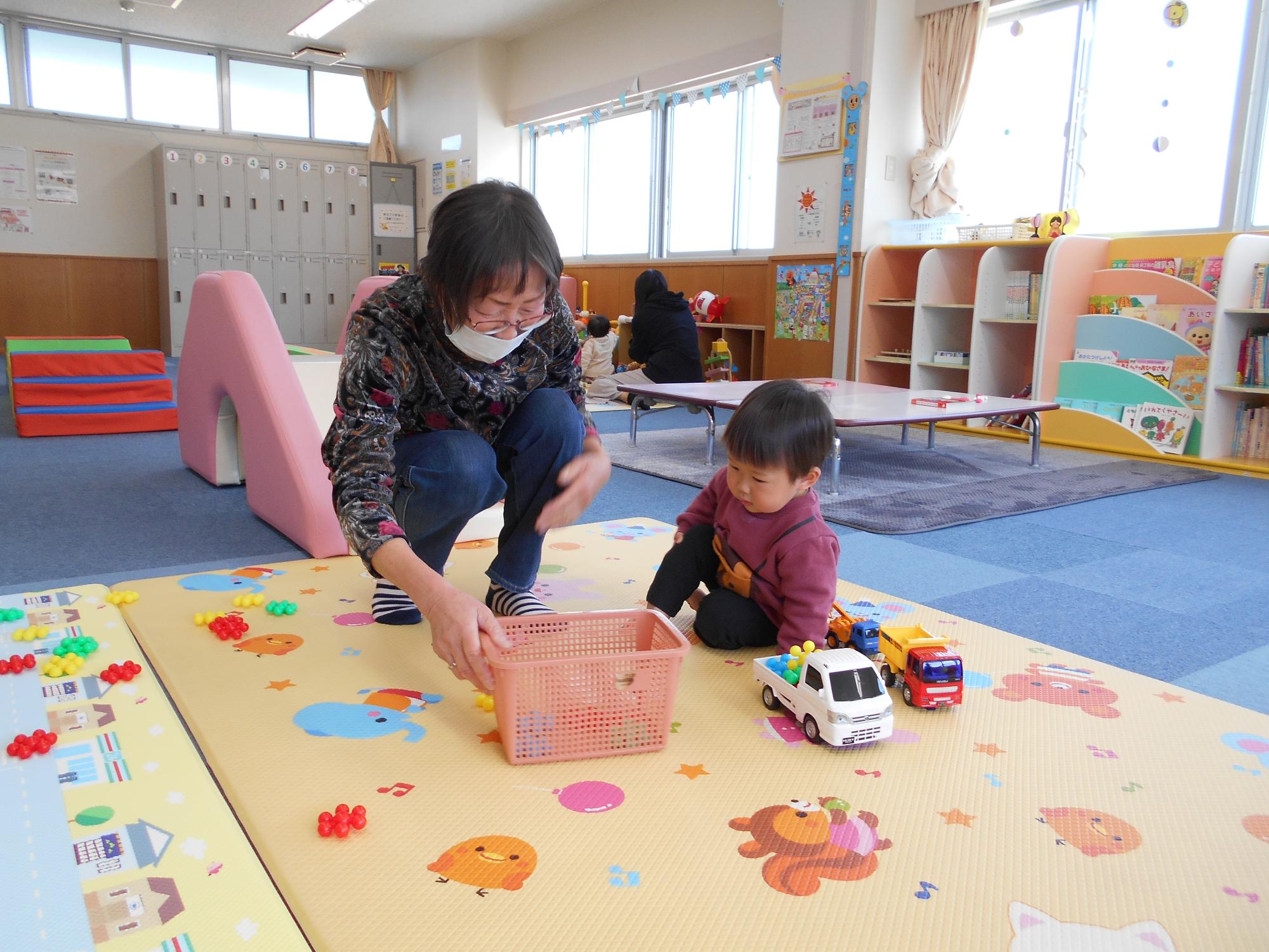 遊びの広場「だっこ」で子育て支援サポーターが子どもと遊んでいる写真