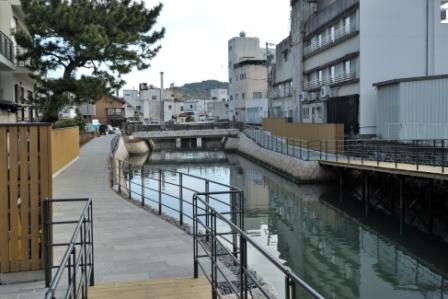 住宅地の中に流れる川沿いに整備された、黒い柵のある妙慶川遊歩道の写真