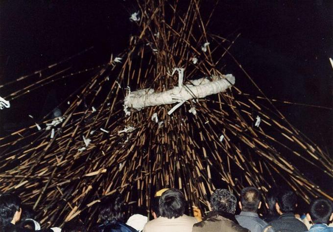 たくさんの細長い竹の先に白い紙をつけ男性たちが大漁を祈願するゲーター祭りの写真画像