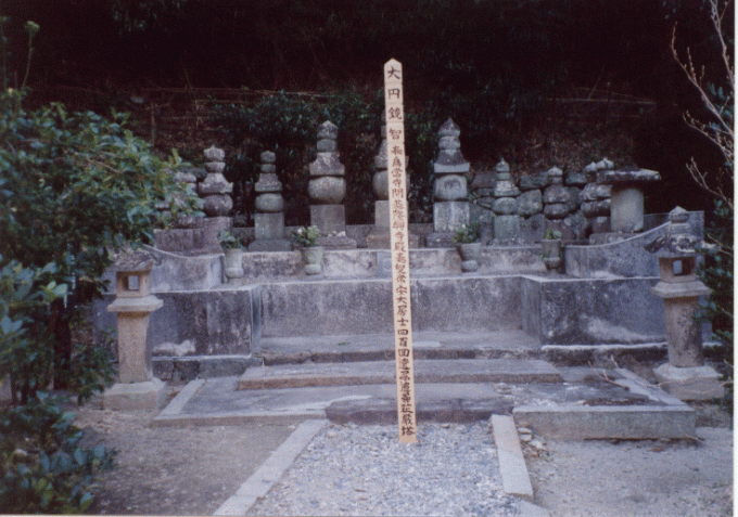 1対の灯籠と複数の墓が立ち並んでいる九鬼家の廟所の写真画像