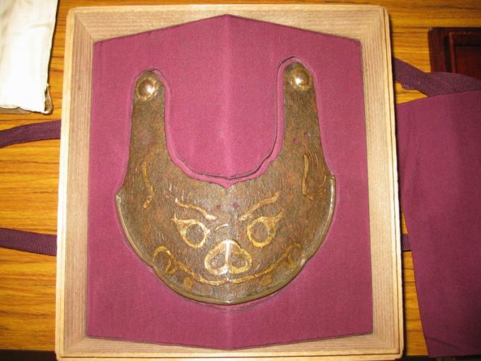 木の箱に入っており鉄鍛造で顔のようなものが描かれている鉄獅噛文金銅象嵌鍬形の写真画像