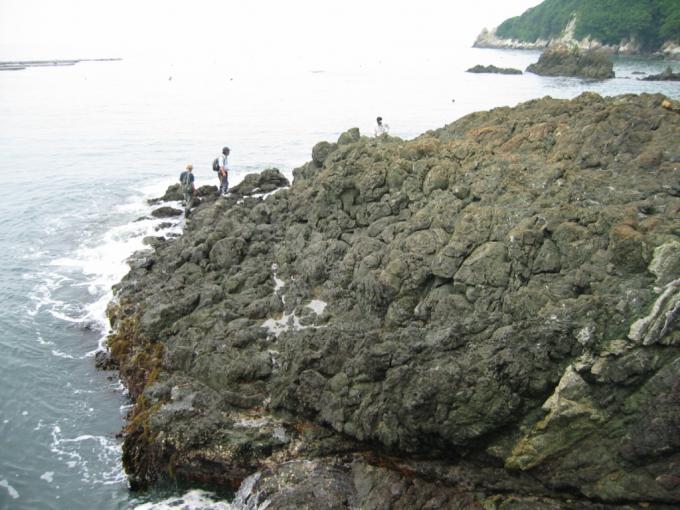 海に面した暗灰色の大村島の枕状溶岩の写真画像
