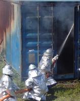 3人の消防団員が防火服を身につけて、ホースによる消火訓練をしている画像